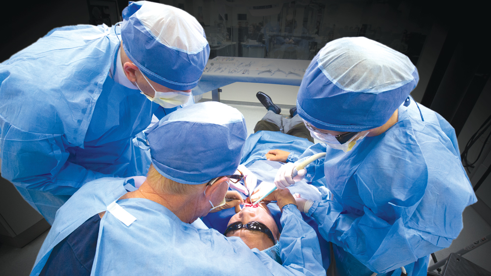 Three dentists operating on patients teeth