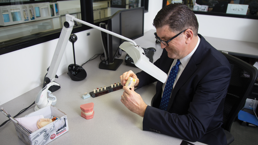 Joe Hattouni looking and holding a BruxZir sample