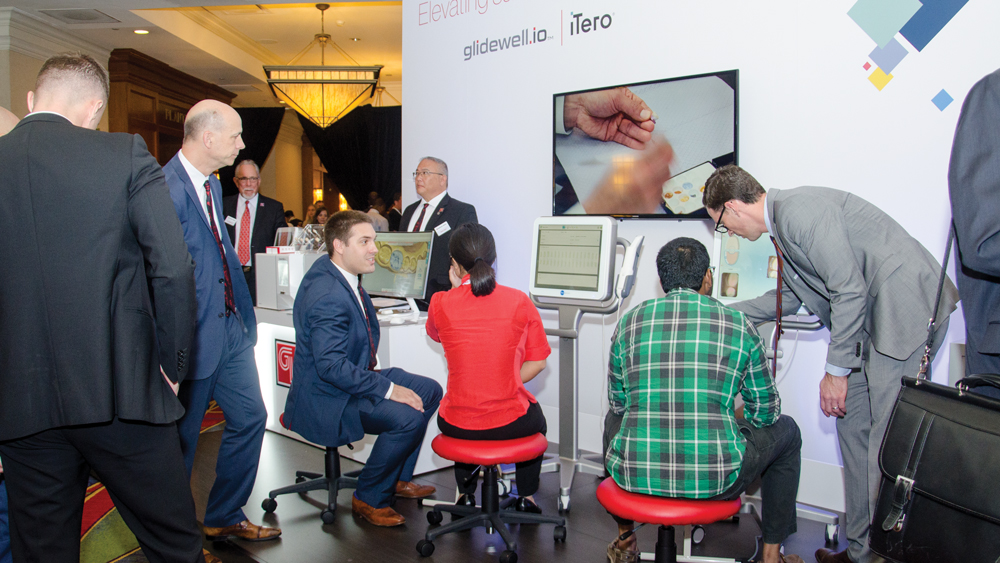 Attendees in the exhibit hall testing glidewell.io In-Office Solution