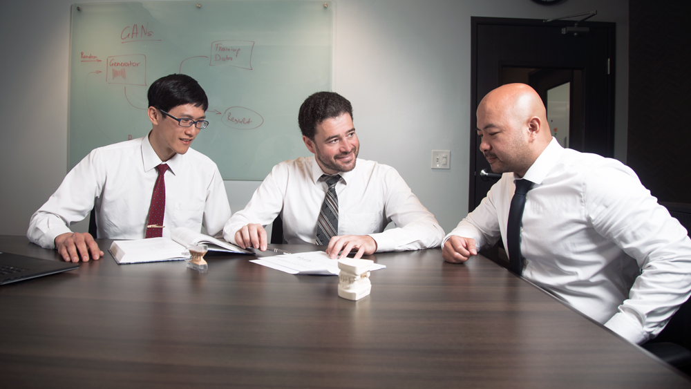 Sergei Azernikov (center), Glidewell Dental machine-learning team lead, collaborates with Chih-Chun Lin (left), CAD software engineer, and David Nguyen (right), research and production manager, at the Glidewell Dental R&D center in Irvine, California