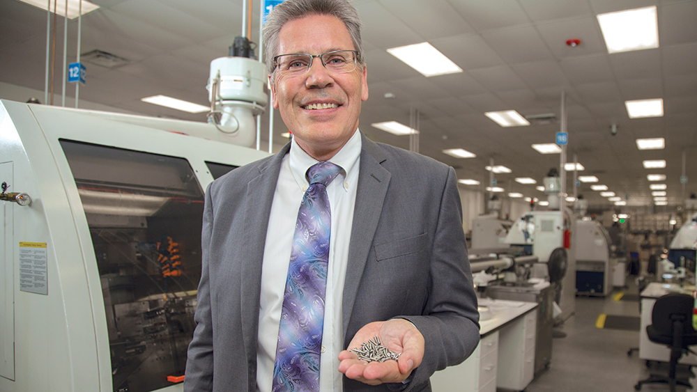 Grant posing for photo holding prosthetic components