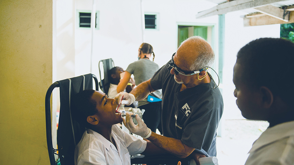 Dr. Greg Moegling checking patient's mouth