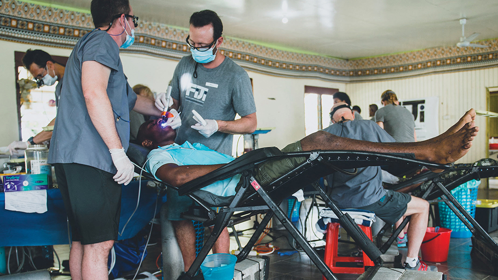 Will Schmidt (right), RDA and clinical operatory manager at Glidewell Dental, works alongside other volunteers at the FDMF clinic