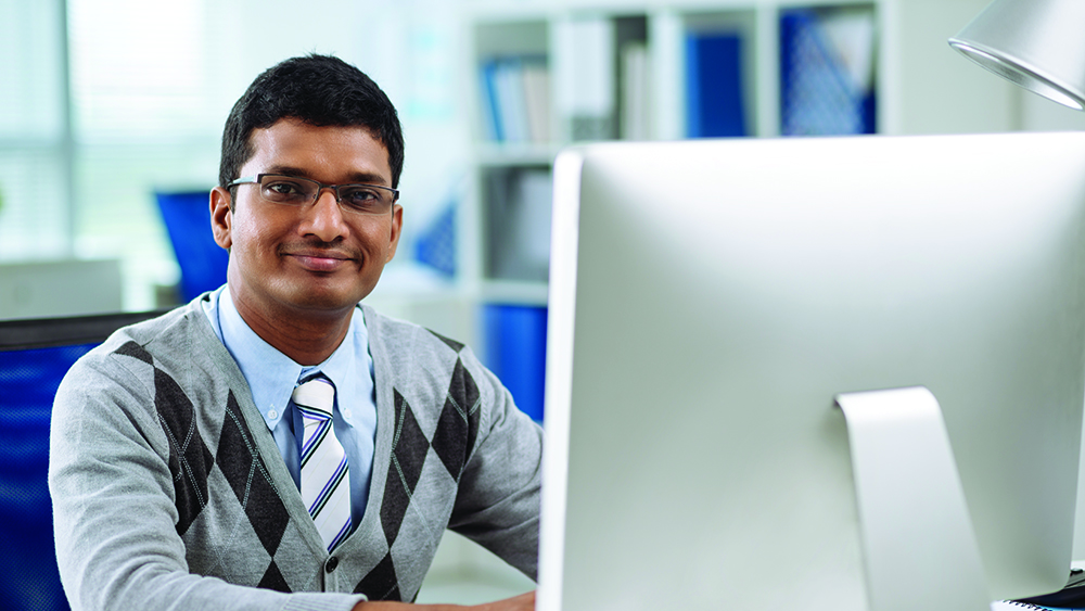 Guy with glasses sitting in front of computer