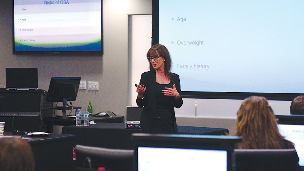 Suzanne Haley lecturing among group 