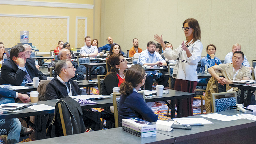 Suzanne Haley lecturing among group 