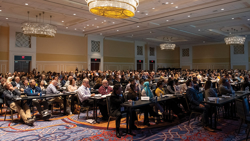 Room full of dentists and practitioners during symposium