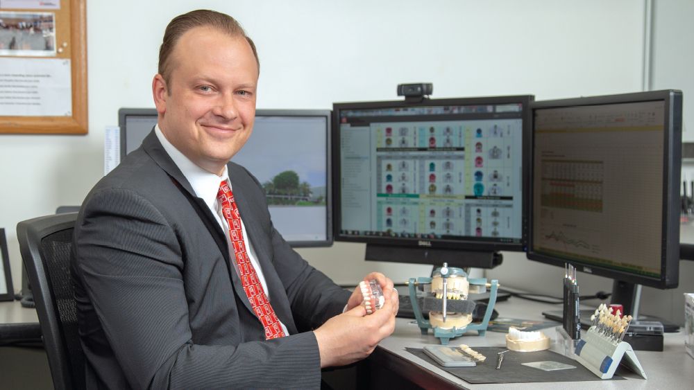 Darius Raudys holding a BruxZir Full-Arch Implant Prosthesis