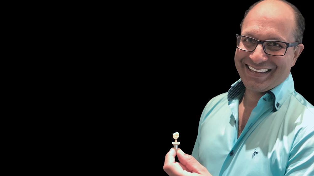 Dr. Joel De Souza holding a BruxZir NOW crown